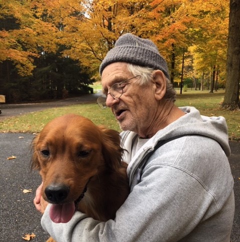 older man holding his dog