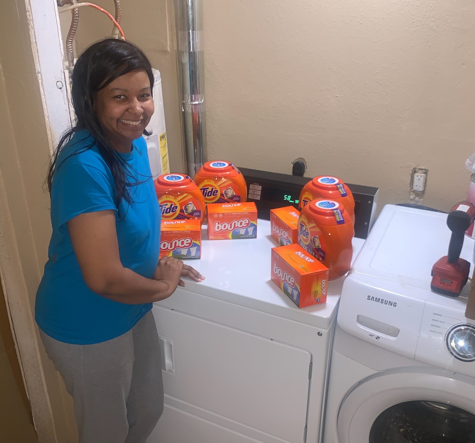 woman smiling at a washing machine