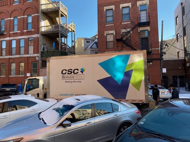 CSC ServiceWorks truck parked in front of a building