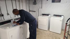 CSC ServiceWorks employee working on laundry machine